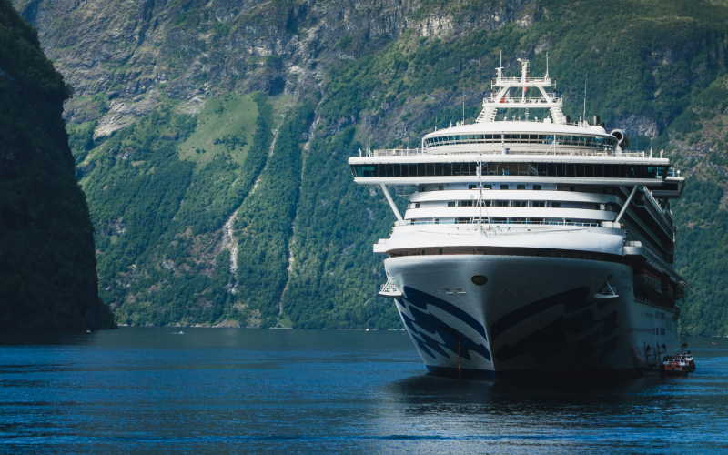  Cruise ship sailing between mountains.